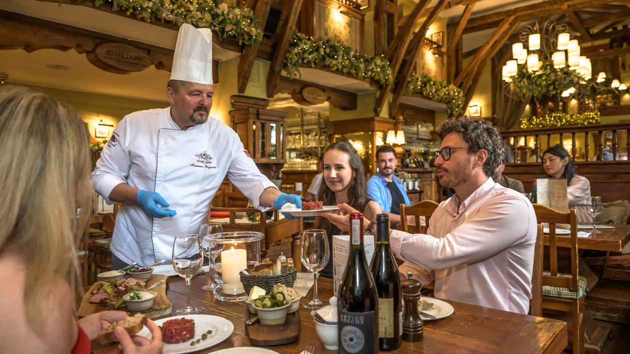 Traditional food experience in Warsaw with a table, wine and a cozy ambiance.