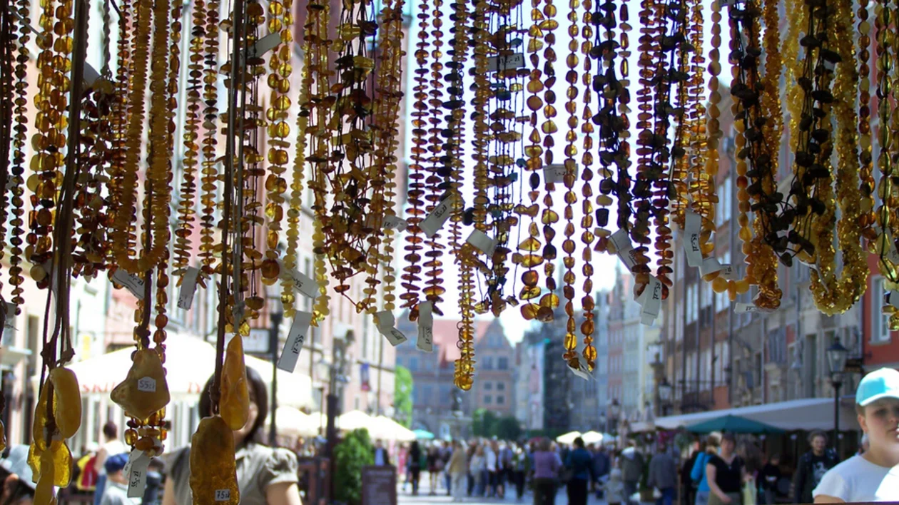 Hanging amber jewelry on display in a busy street market.