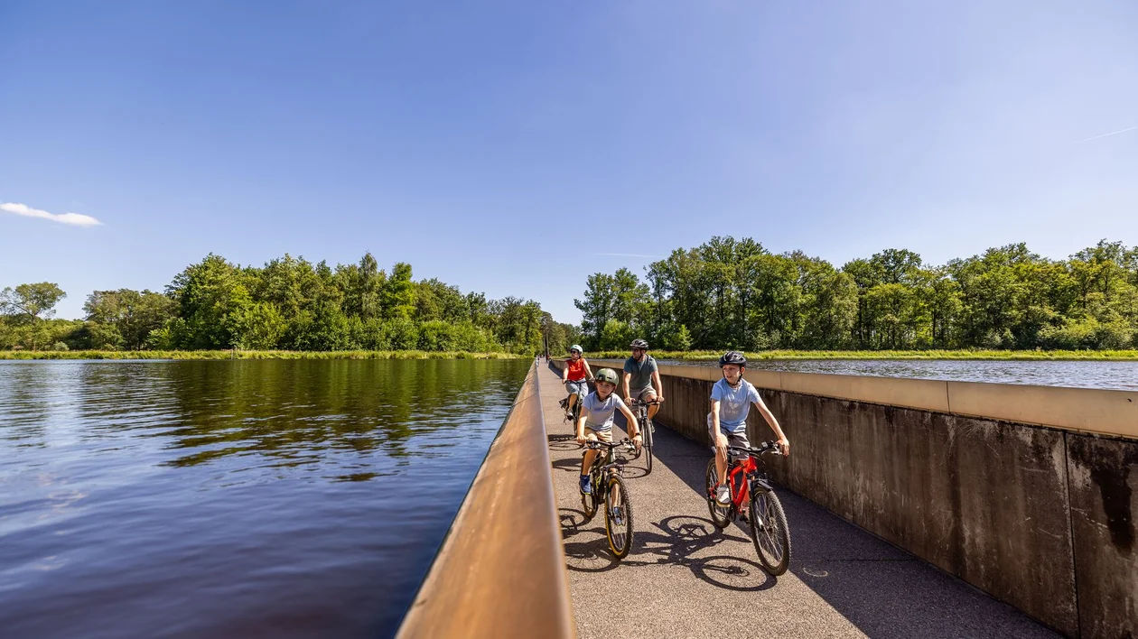 Cyclist holding a card with another cyclist in the background.