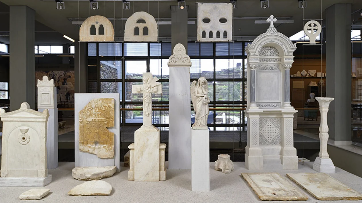 A display of various ornate marble artifacts, including tombstones, sculptures, and decorative panels in a museum setting.