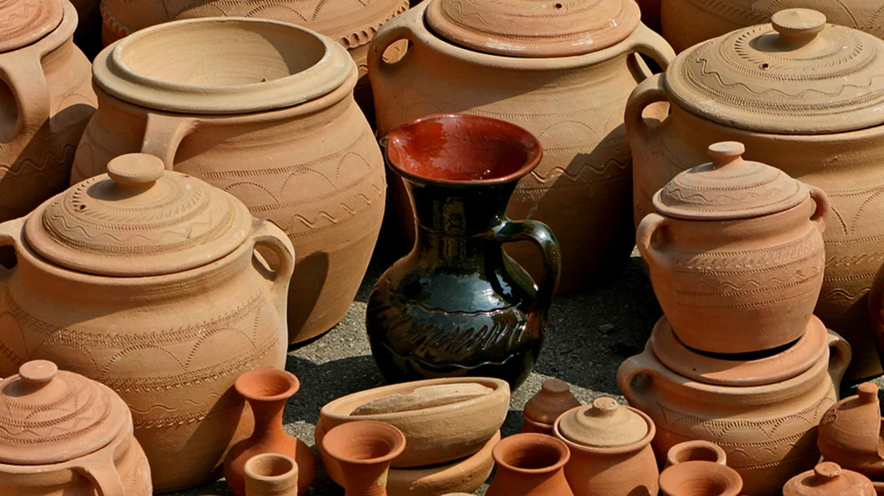 A collection of handcrafted clay pots and jugs of various sizes, showcasing intricate designs and earthy tones.