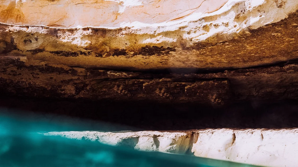 A young boy jumping in the St. Peters' Pool in Malta on a sunny day.