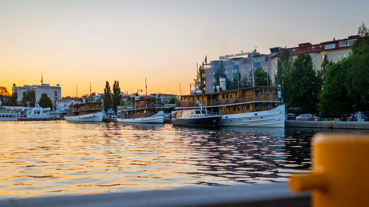 Boats docked at the harbour of Savonlinna, Finland, during a colourful sunset.