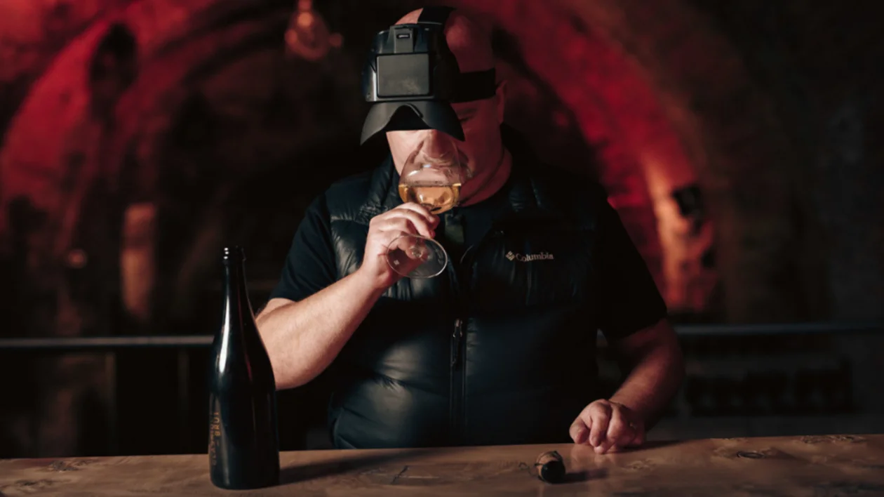 Winemaker tasting sparkling wine in darkness, part of Slovenia’s unique ‘Untouched by Light’ concept.