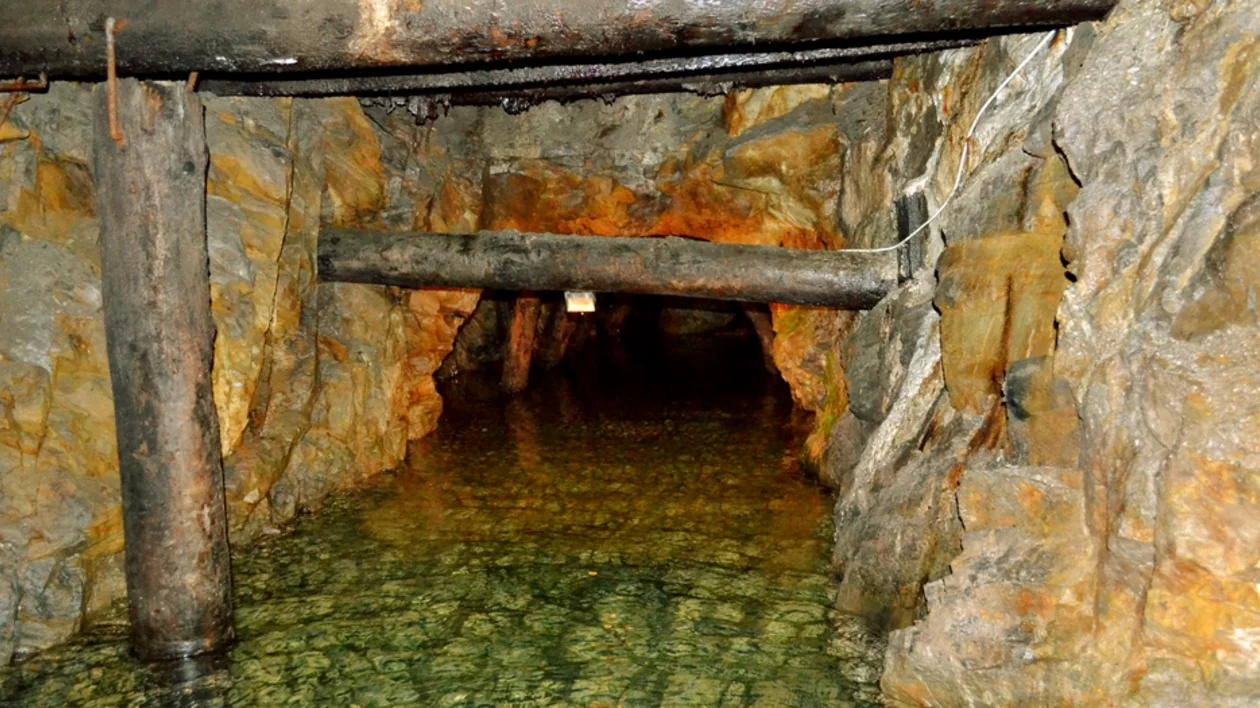 Subterranean passage in the Riese complex surrounded by rocks and water.