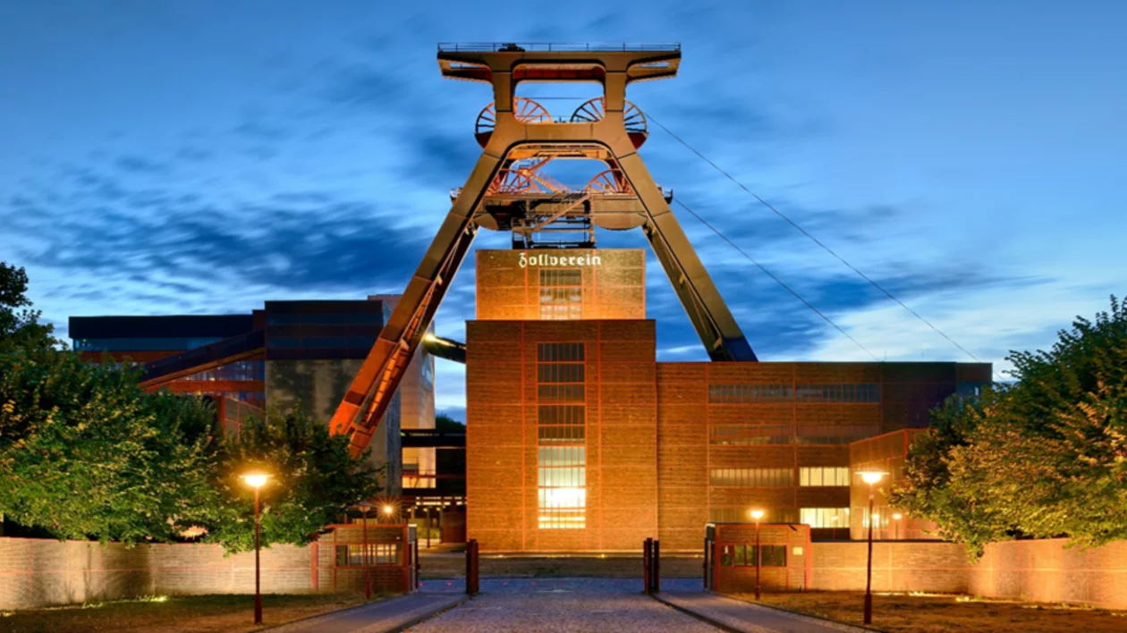 Heritage-listed Zollverein Colliery in Essen, Germany, illuminated at night with architectural lighting highlighting its industrial structures.