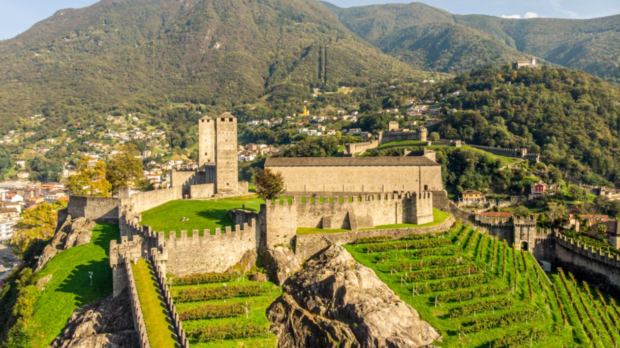 Castelgrande fortress nestled in the Swiss Alps, surrounded by lush green hills and scenic mountain landscape.