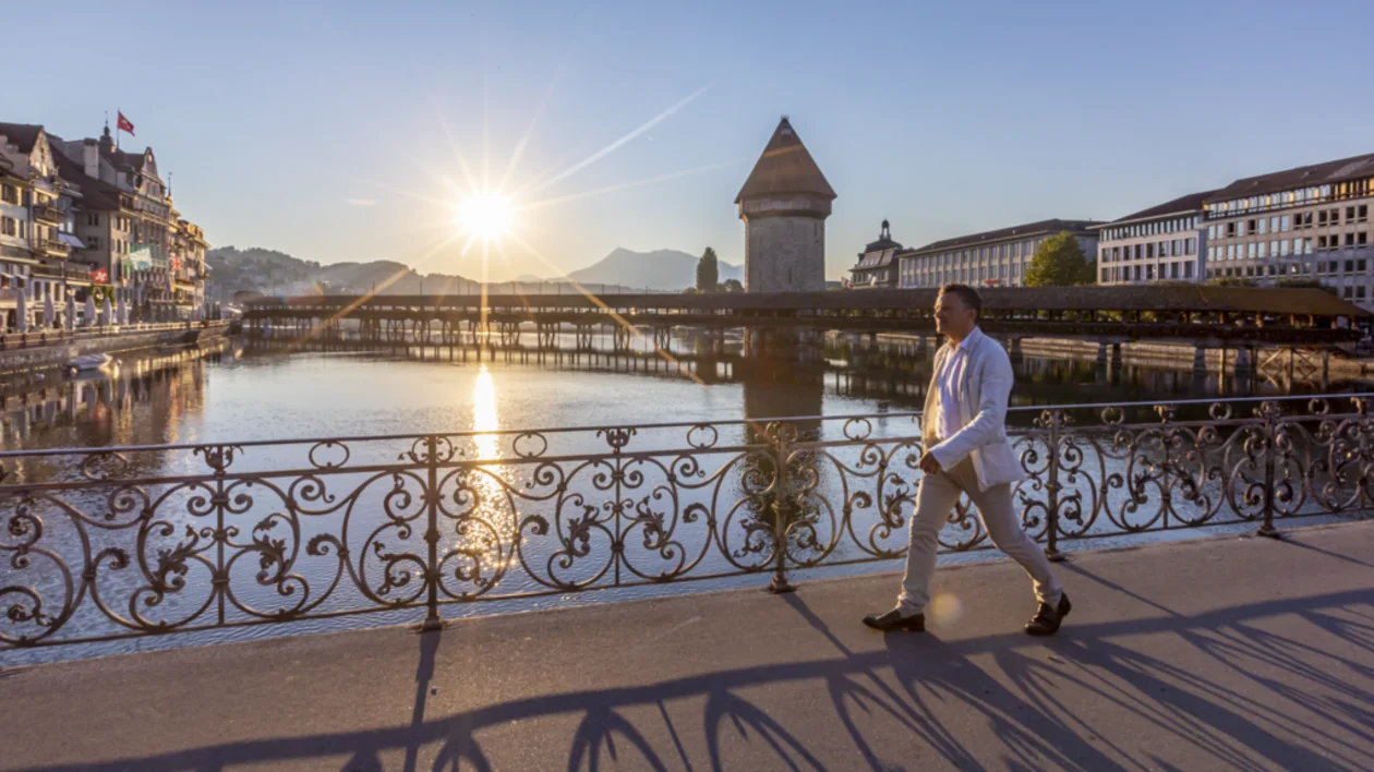 Panoramic aerial view of Lucerne, Switzerland, with Lake Lucerne, old town rooftops and surrounding alpine hills.