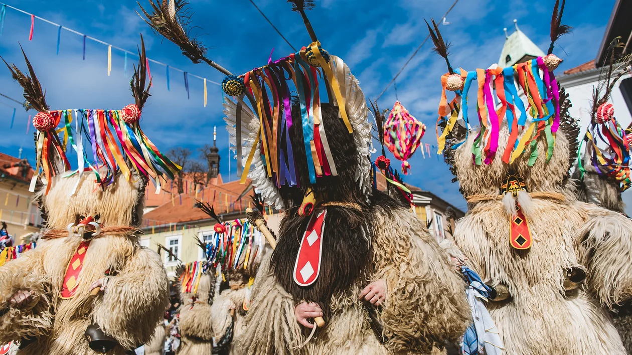 Traditional Kurentovanje festival performers wearing shaggy sheepskin costumes and colourful ribbon masks in Slovenia.
