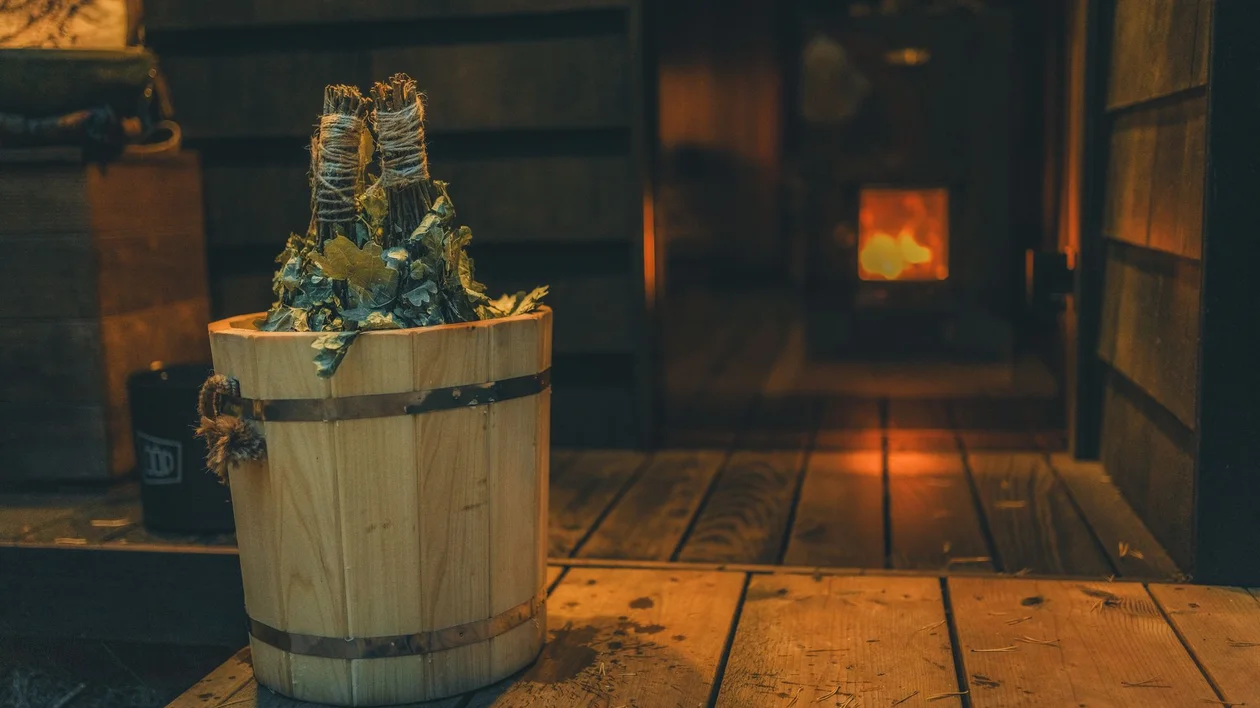 Traditional sauna interior with wooden bucket and fire in background