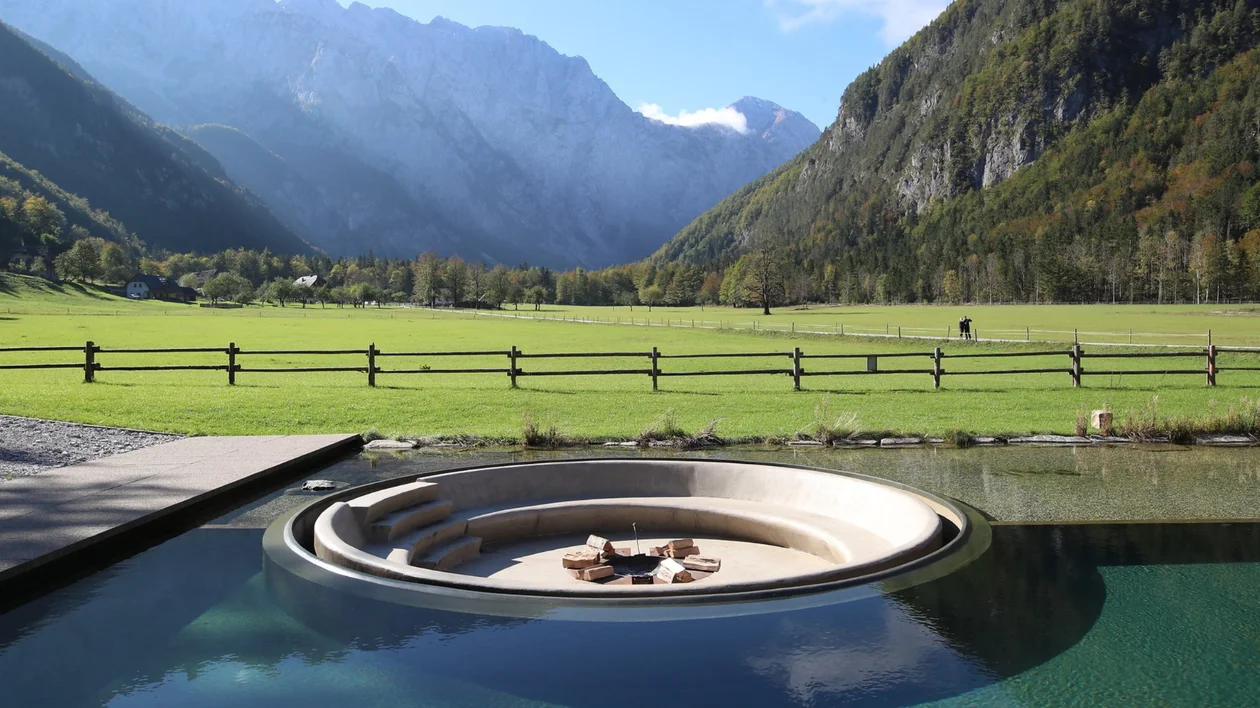 Sunken fire pit beside alpine meadow and mountains