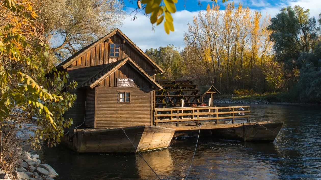 Traditional wooden floating mill on a calm river