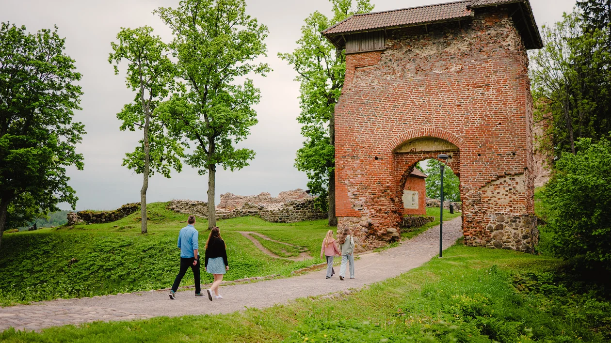 Visitors walking through the medieval gate at Viljandi Castle ruins in Estonia