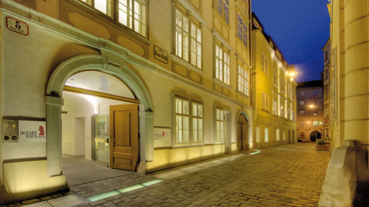 Mozarthaus Vienna at night with softly lit historic facade on a quiet cobblestone street.