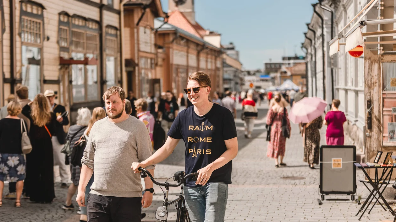 People walking along a historic wooden street in Rauma, Finland