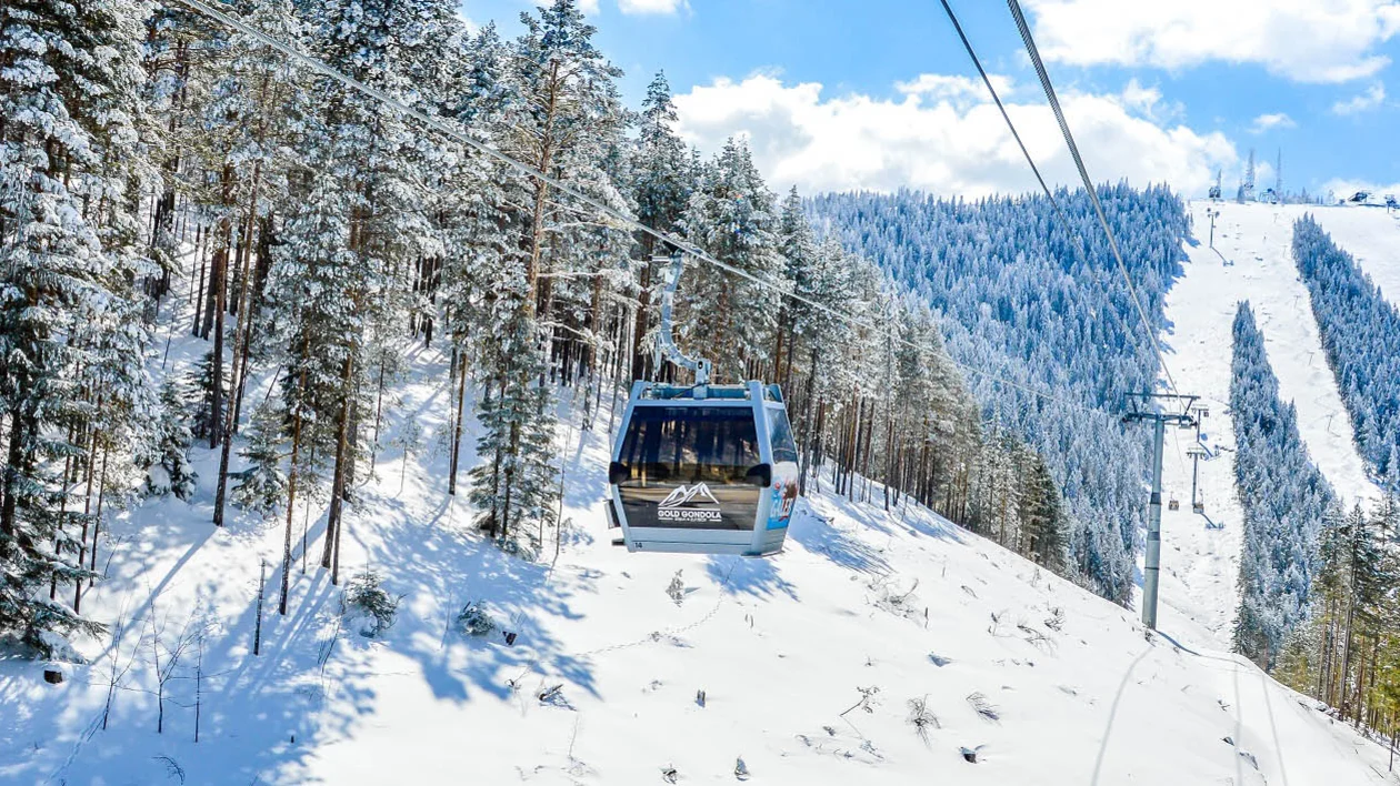 Gold gondola cable car above snow-covered forest in Zlatibor, Serbia