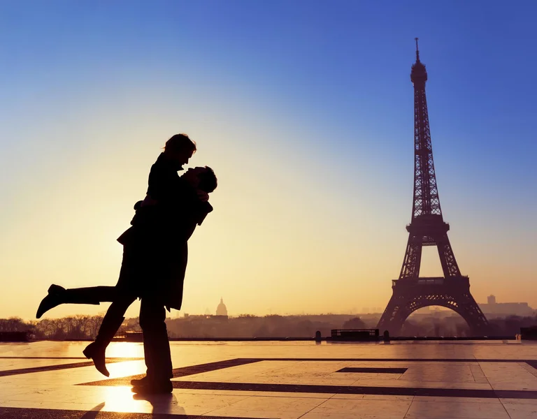 A couple enjoying sunset in front of Eiffel Tower in Paris
