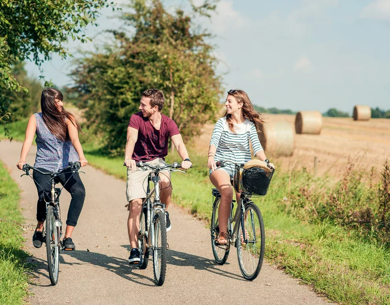 Eurovelo 7, three people cycling with the stunning landscape on the back.