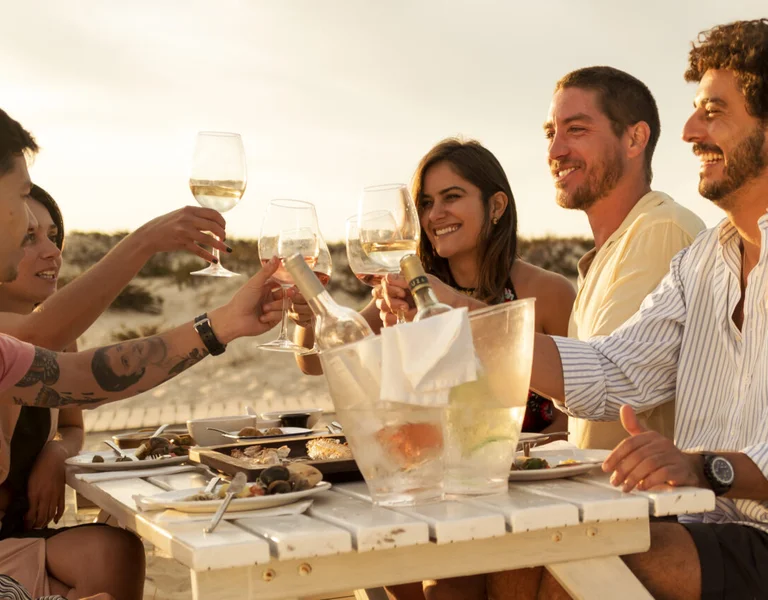 People are drinking wine and tasting local food.