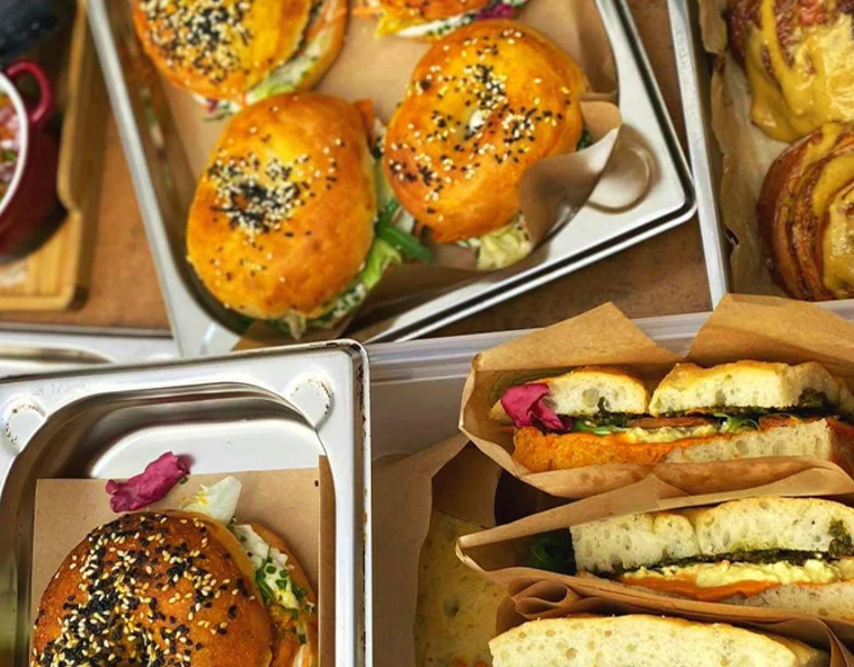 A table displaying burgers, bakery and sandwiches.