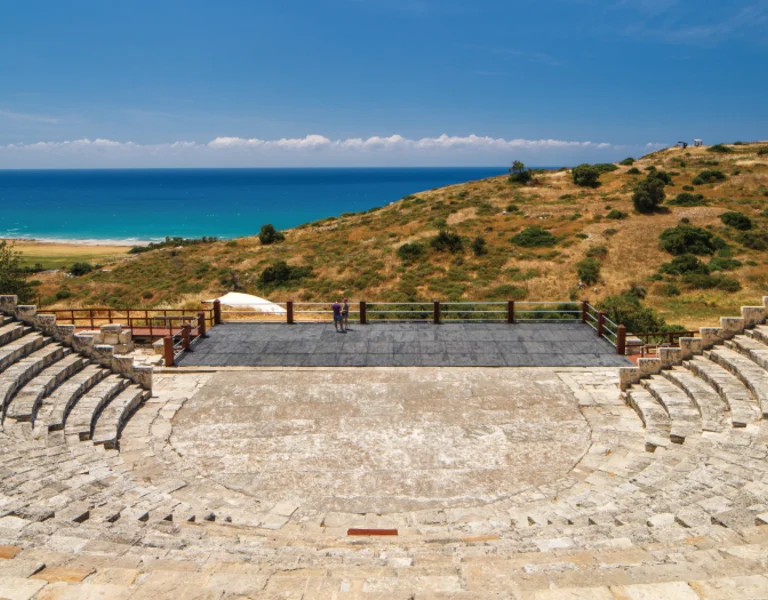 Ancient amphitheater with sea view under a blue sky.