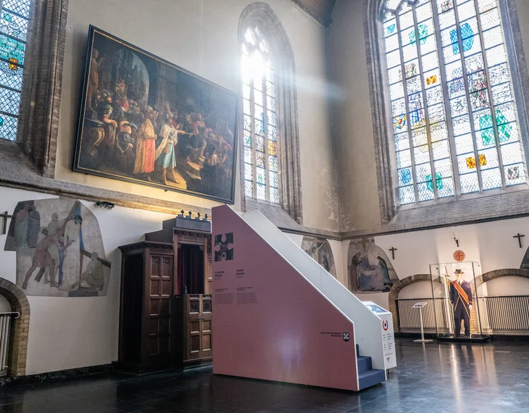 Interior of a church adorned with medieval paintings, featuring a stained glass window with multicolored designs.