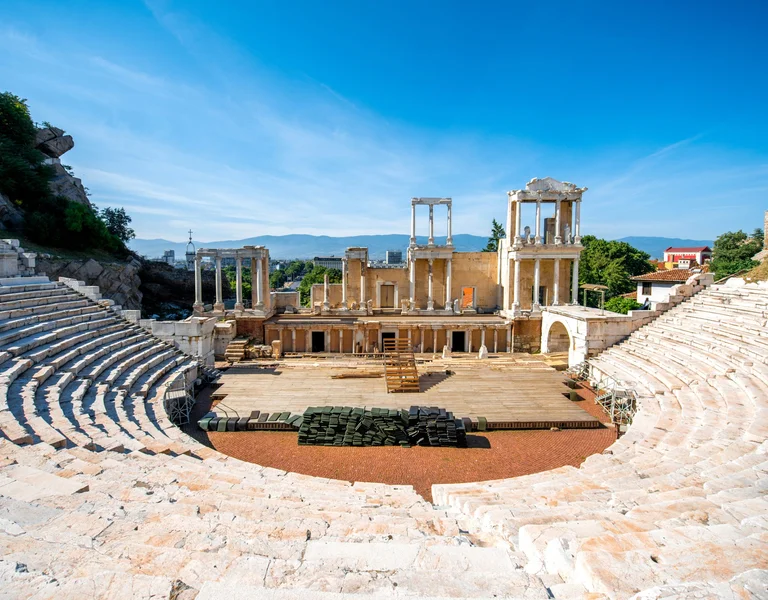 Panoramic view of the well-preserved Roman theatre in Plovdiv, with marble seating and a grand stage backdrop.