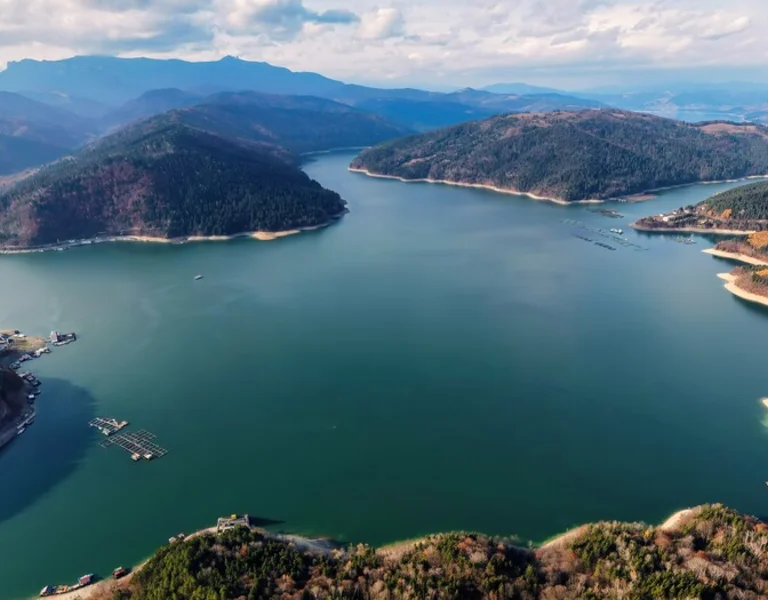 Panoramic view of Bicaz Lake with winding shores and forested hills.