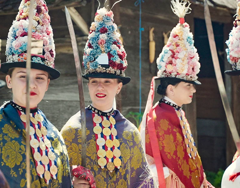 Traditional Ljelje dancers from Gorjani wearing floral ceremonial headdresses and folk costumes in Croatia.