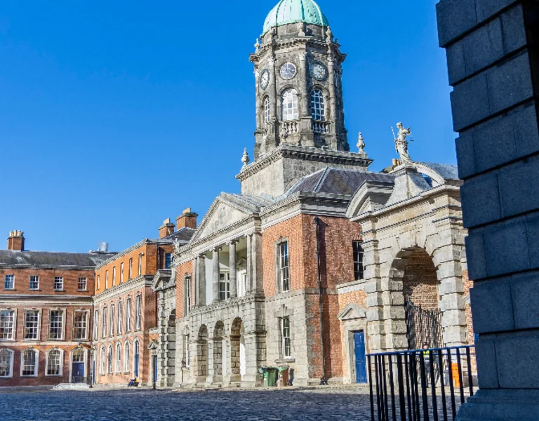 Dublin Castle in Dublin City, historic stone buildings and clock tower under a clear blue sky.