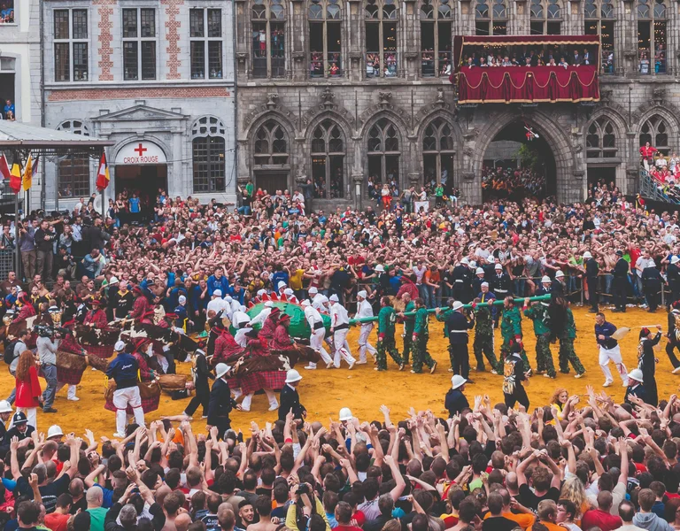 Large crowd gathered in a historic square for a colorful public event or celebration.