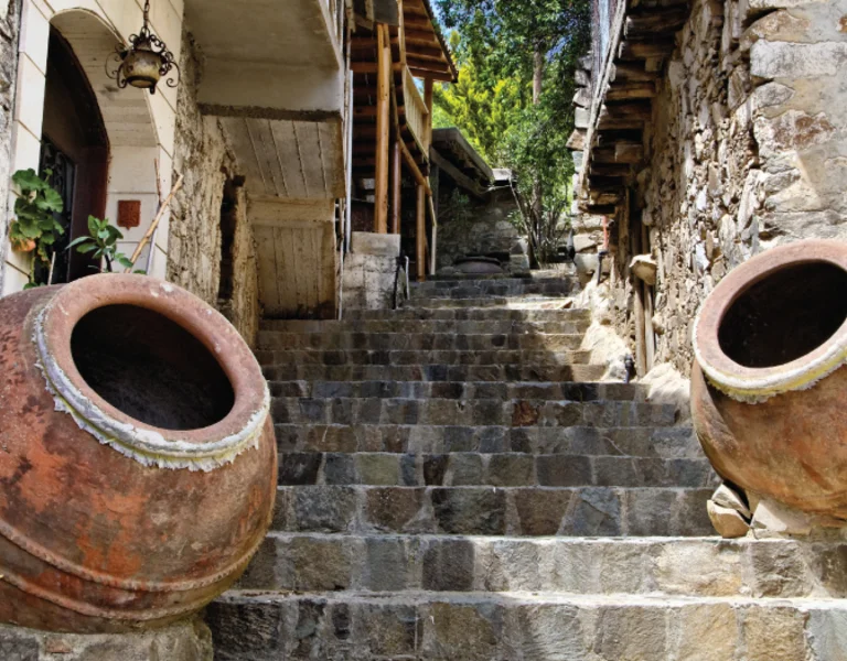 Stone steps with two large clay pots on either side, set in a rustic outdoor alley.