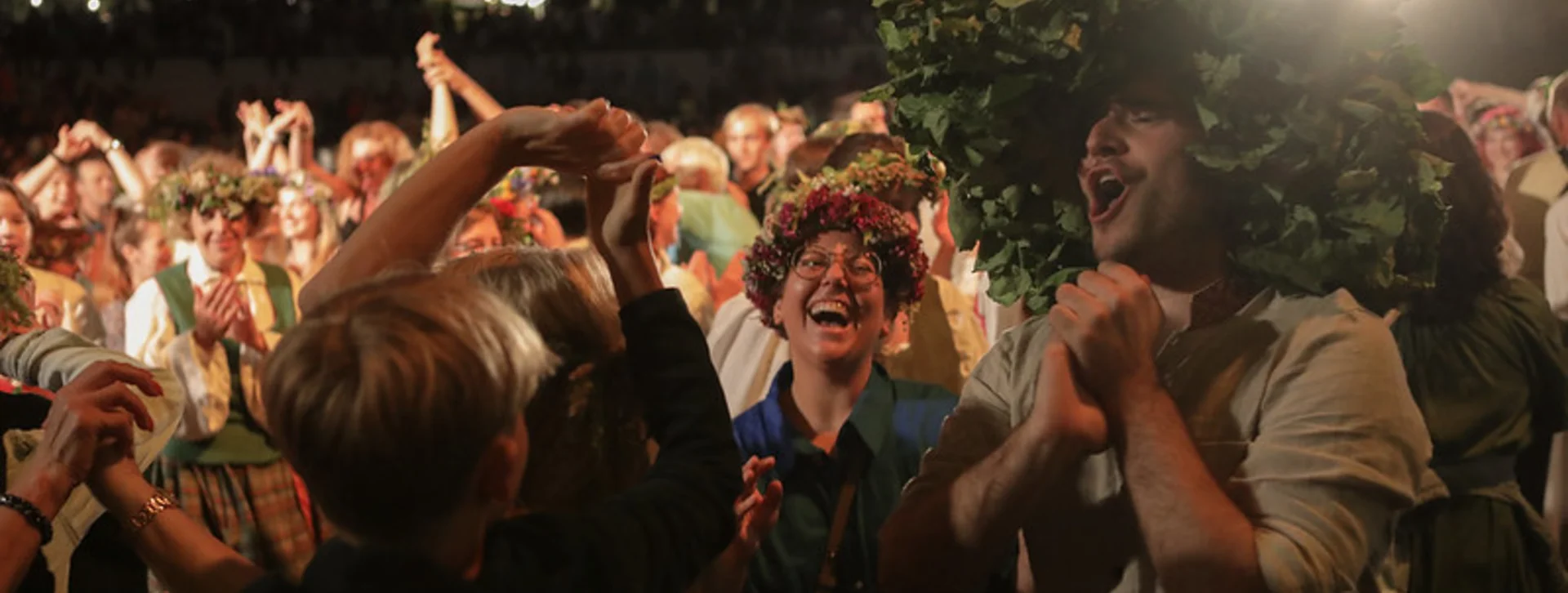A group of people celebrating local Midsummer traditions in Riga.