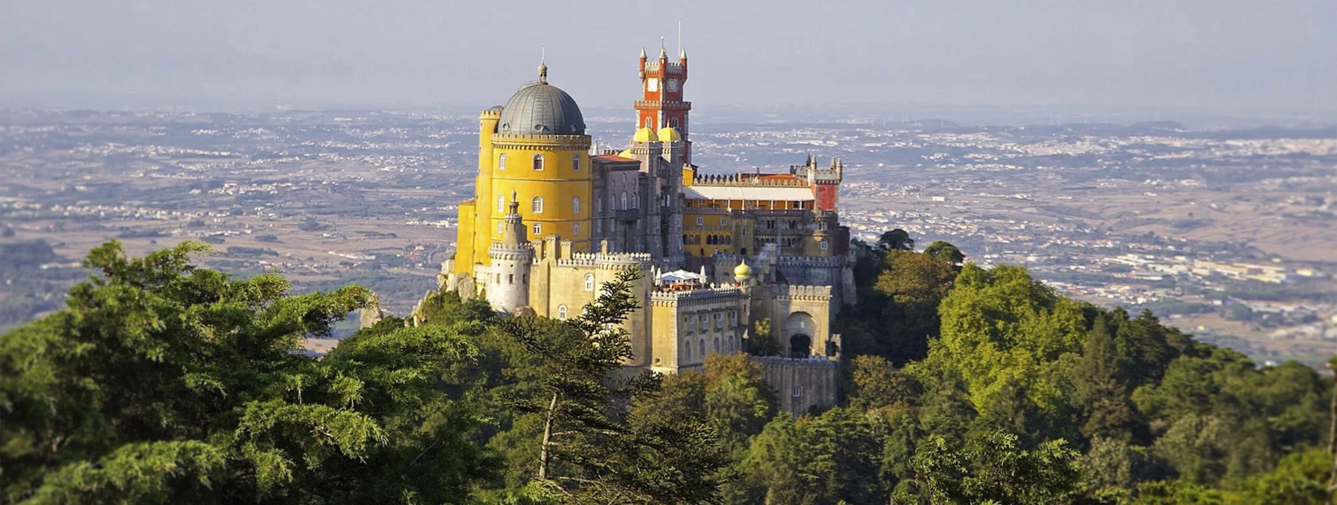 Colourful hilltop palace above forested hills