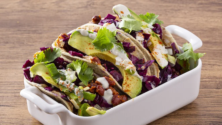 How can you resist soft tacos filled with plant-based ingredients including avocado, cabbage, and cilantro, topped with a creamy dressing?