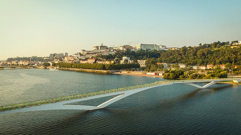 Modern pedestrian bridge with colourful railings spanning the Mondego River in Coimbra.