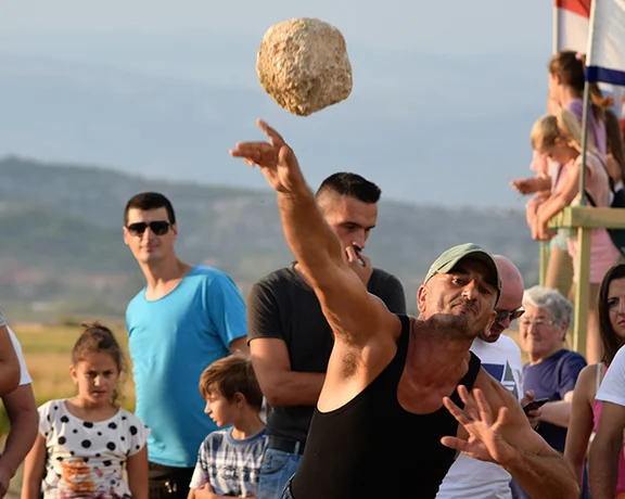 Catch an action shot as a man throws his stone during a plow competition!