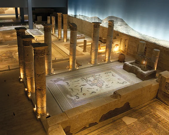 Ancient stone ruins with pillars and mosaic floors displayed in the Zeugma Mosaic Museum in Gaziantep.