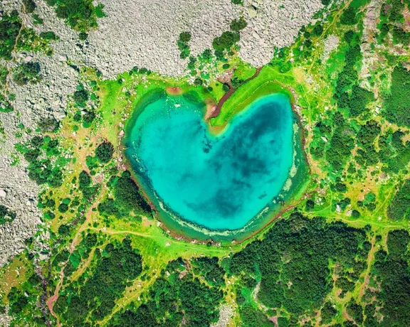 Heart-shaped alpine lake surrounded by rocky terrain.