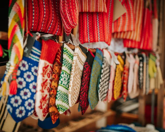 Locally made wool mittens displayed at the Vormsi Farm Museum, featuring traditional colorful patterns in red, green, black, and blue.