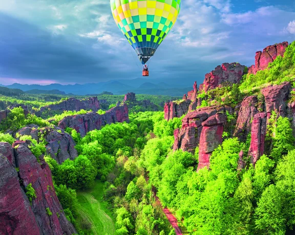 Colorful festival lights and decorations between the dramatic Belogradchik rock formations in northwestern Bulgaria, set against the rugged mountains.
