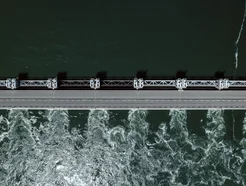 Aerial view of a dam with water flowing beneath a bridge structure.
